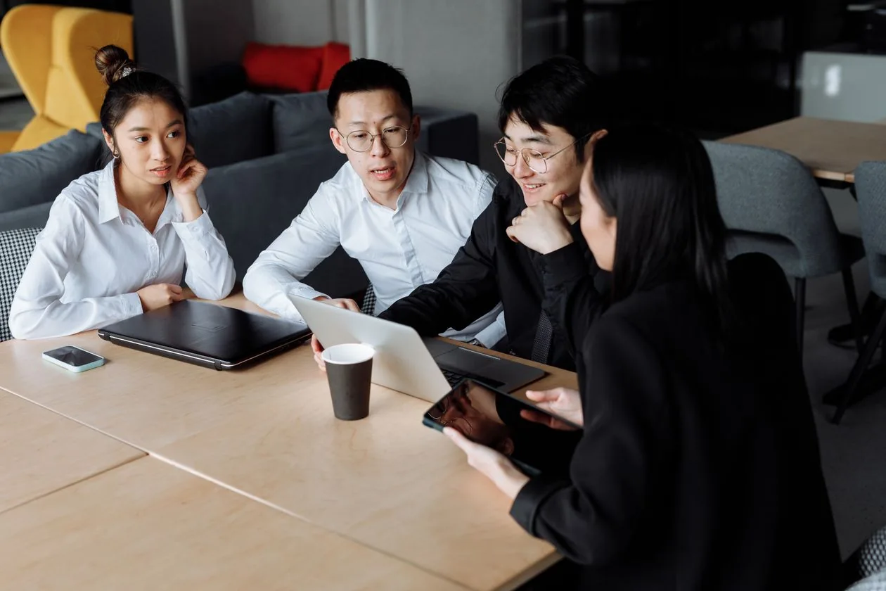 Colleagues exchanging ideas around a laptop